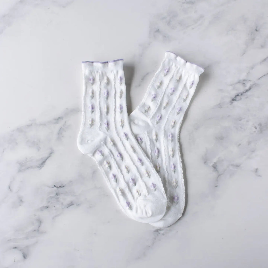 A pair of Tiepology Pastel Color Floral Casual Socks, displayed on a marble surface, featuring breathable fabric.