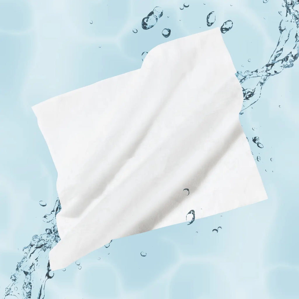 A single white napkin surrounded by splashing water on a light blue background.