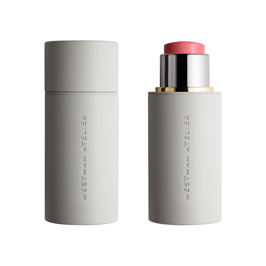 Two Westman Atelier Baby Cheeks Blush Stick makeup products featuring natural ingredients, a closed light grey container next to an open one revealing a pink lipstick.