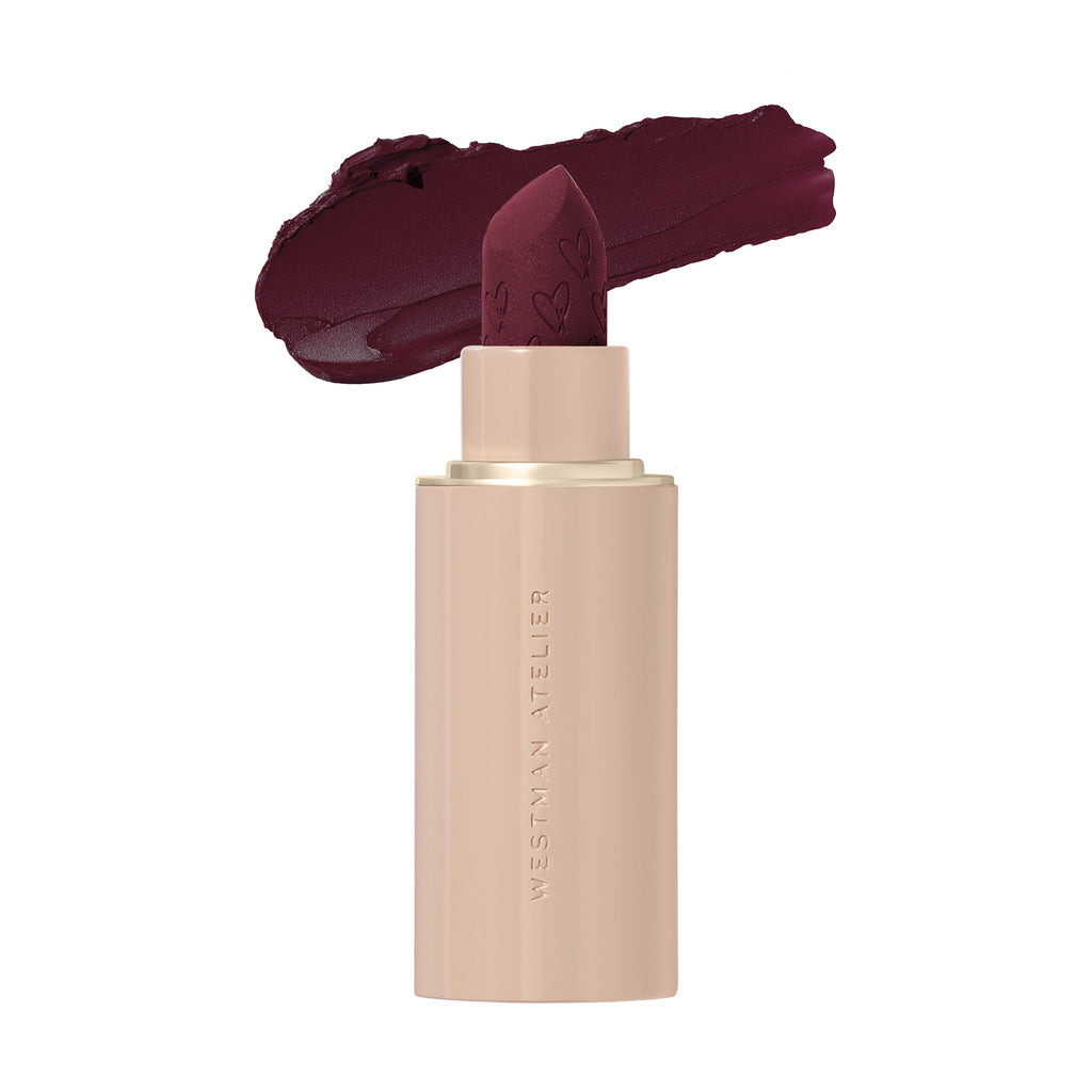 A tube of lipstick with the cap off and a rich, dark shade of lipstick twisted up.