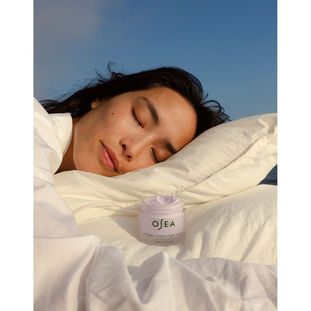 A person peacefully sleeping with a jar of "osea malibu dream night cream" by their side.