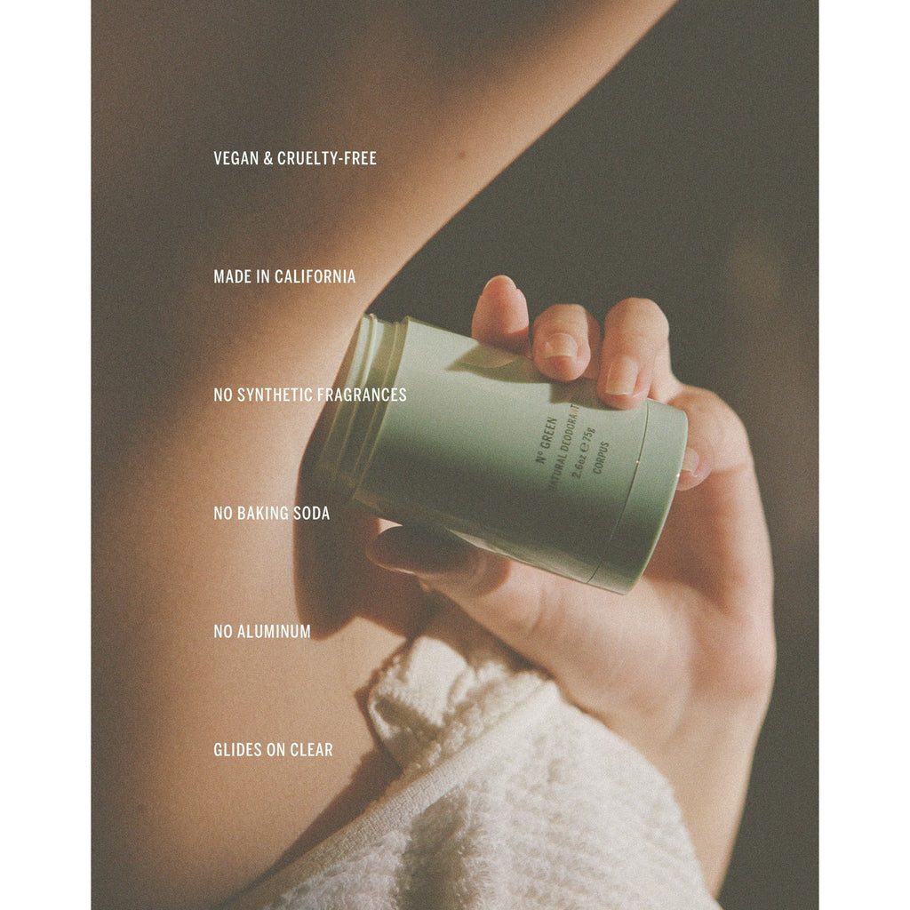 Hand holding a CORPUS Naturals Deodorant with product details highlighted by sunlight.
