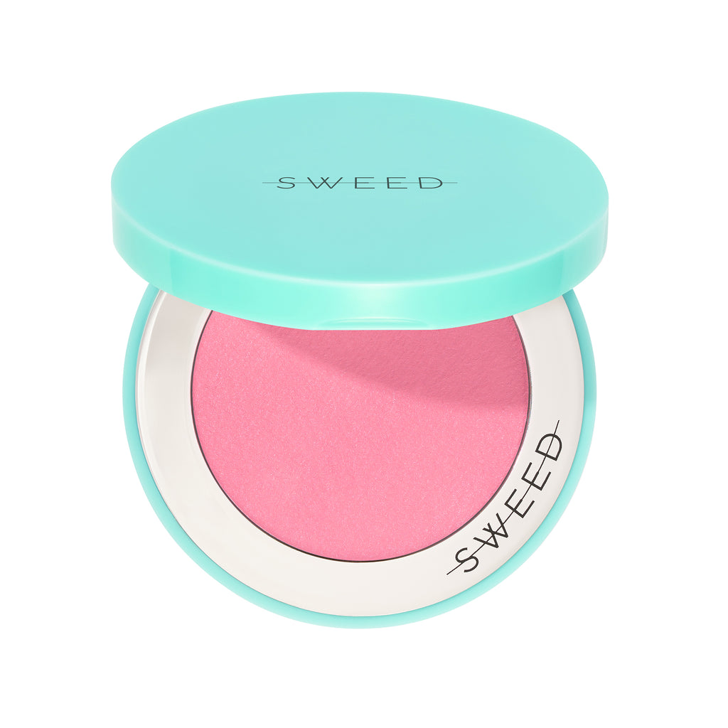 Compact blush in a turquoise container with brand name.