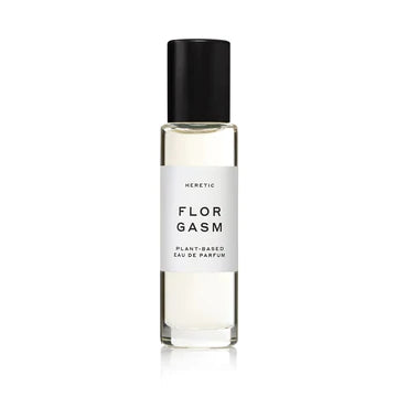 A glass perfume bottle labeled "Heretic Parfum Florgasm" with black cap on a white background, infused with jasmine fragrance.