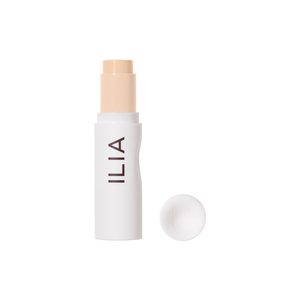 A stick foundation by ilia with the cap placed beside it.