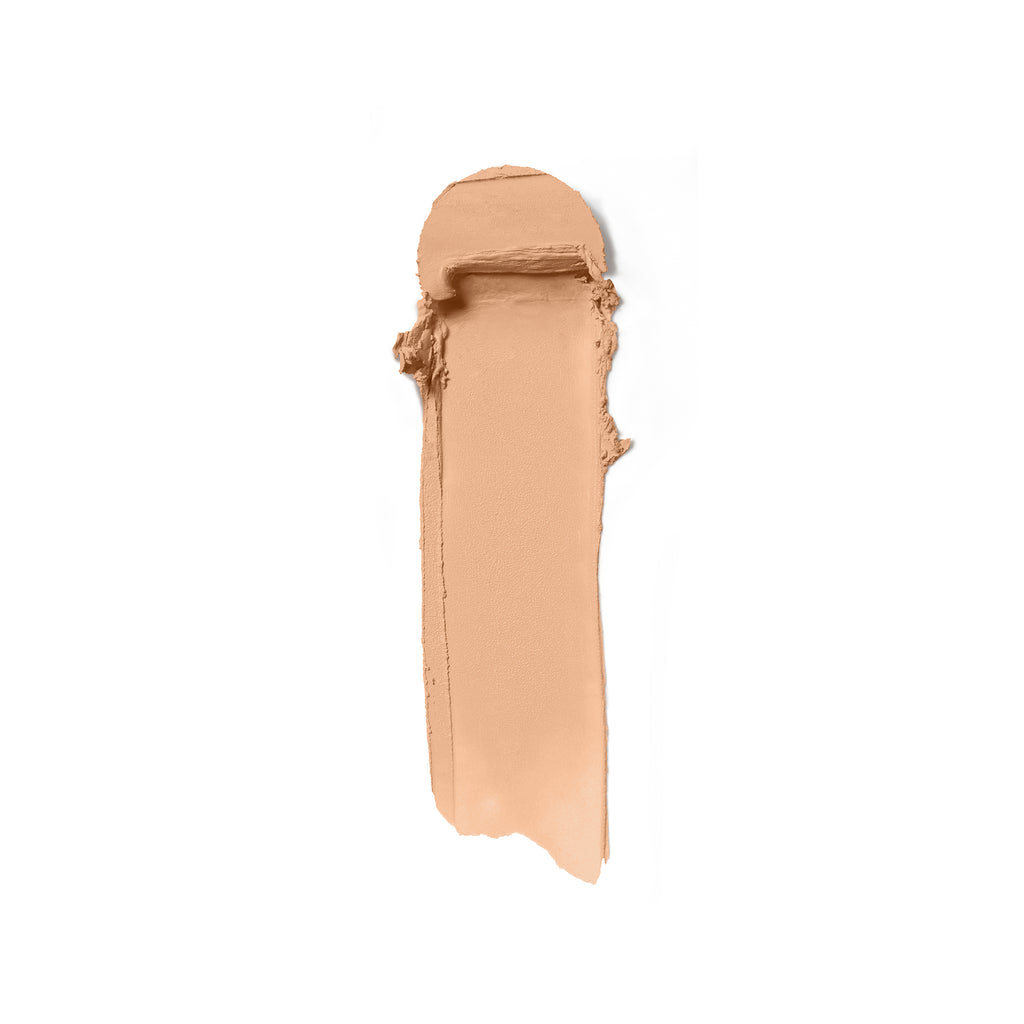 A swatch of beige foundation makeup smeared on a white background.