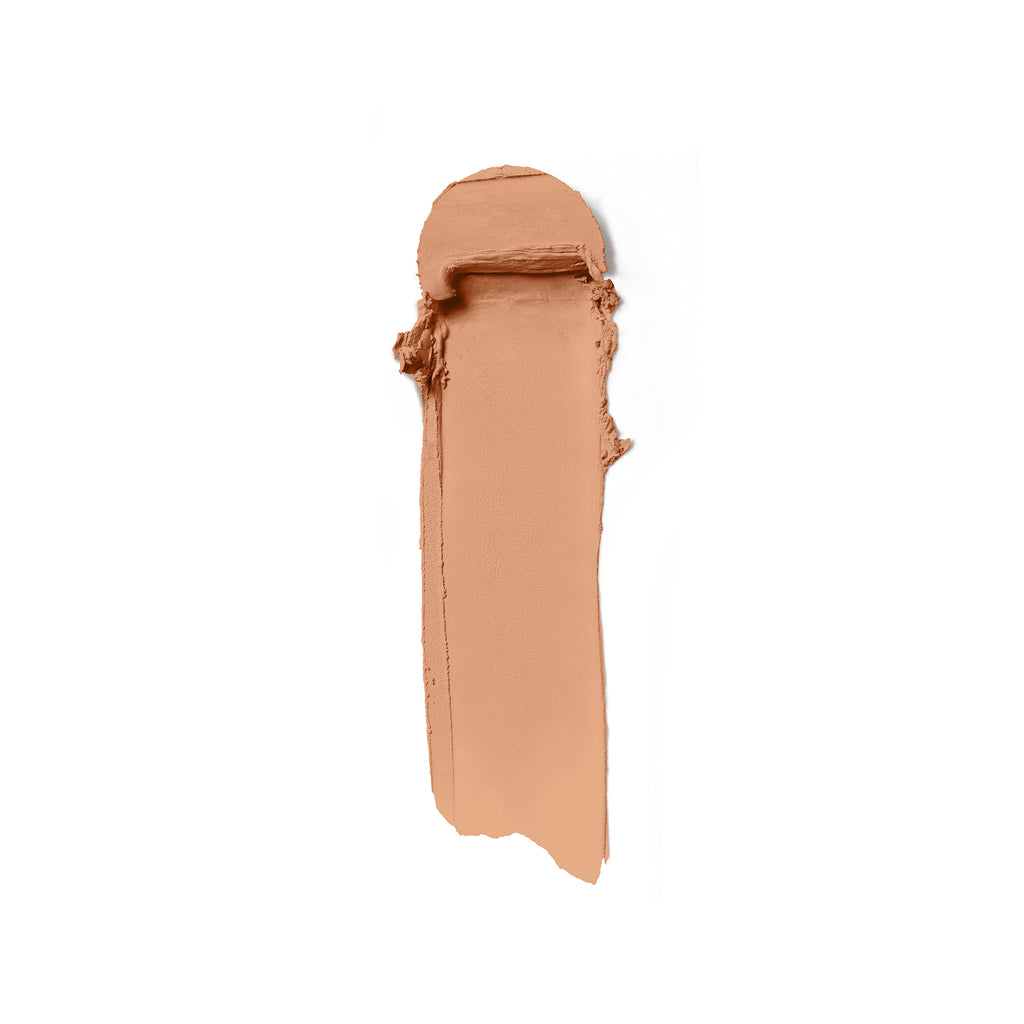 A swatch of beige cream makeup smeared on a white background.