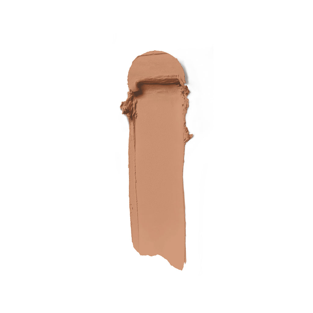 A tan colored conceal stick on a white background.