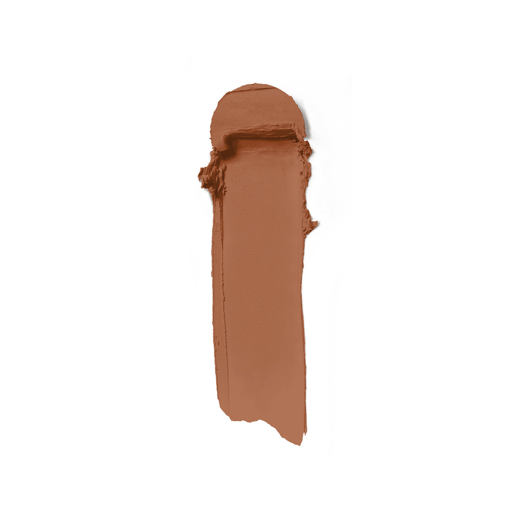 A swatch of brown creamy substance, possibly makeup, against a white background.