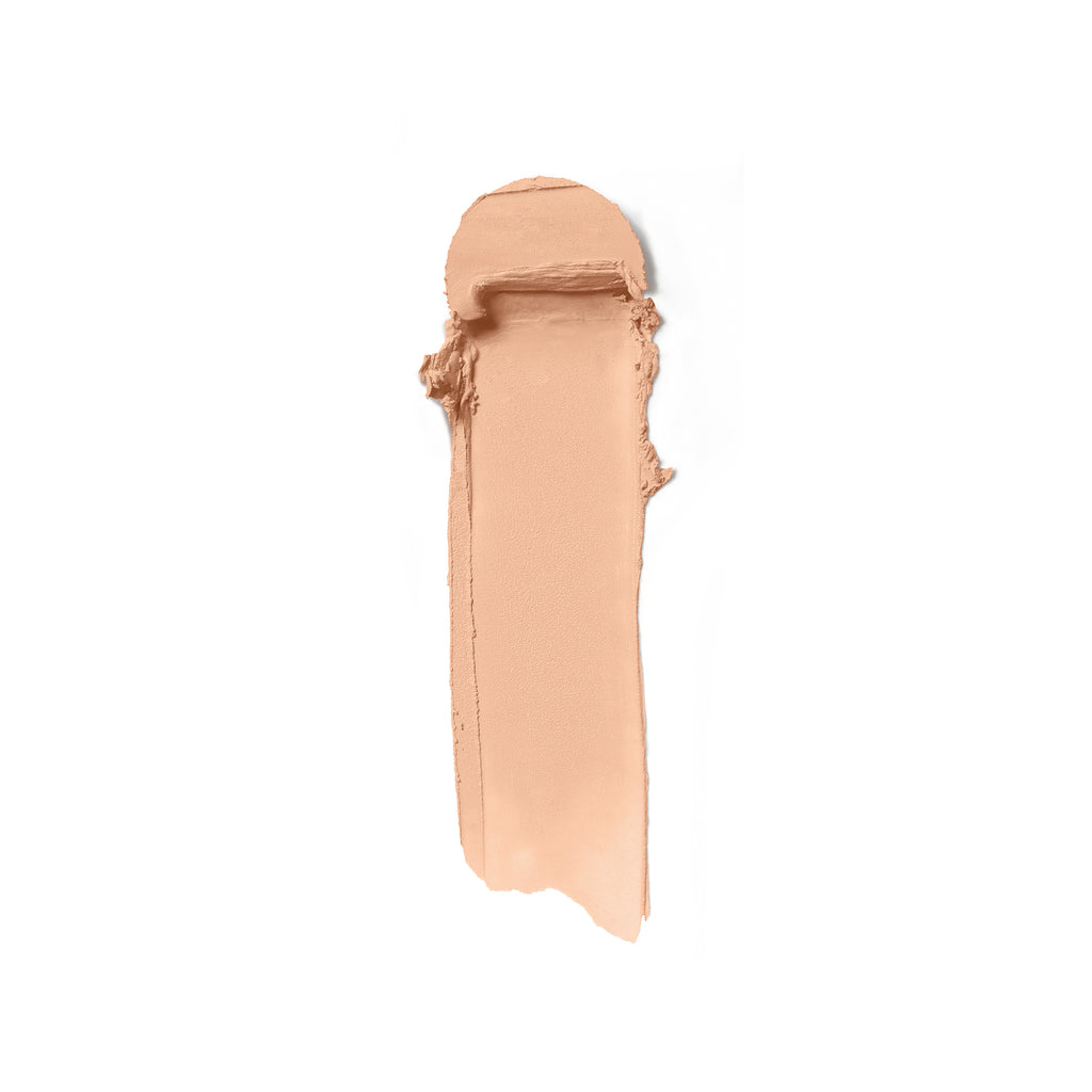 A swatch of beige foundation makeup smeared on a white background.