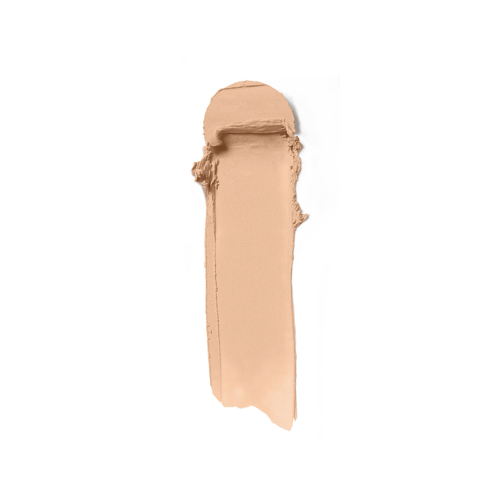 A swatch of liquid foundation makeup smeared on a white background.