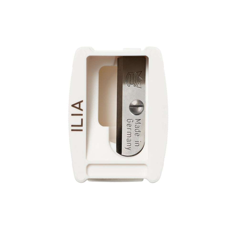 White ilia branded Ilia Sharpener with an open lid, showing a metal pan stamped with "made in germany.