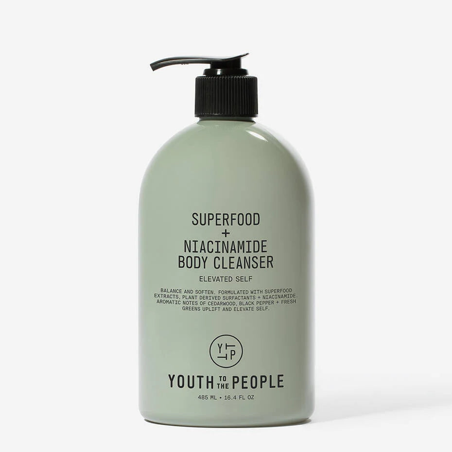 A green bottle of Youth To The People Superfood + Niacinamide Body Cleanser with a black pump, isolated on a white background.
