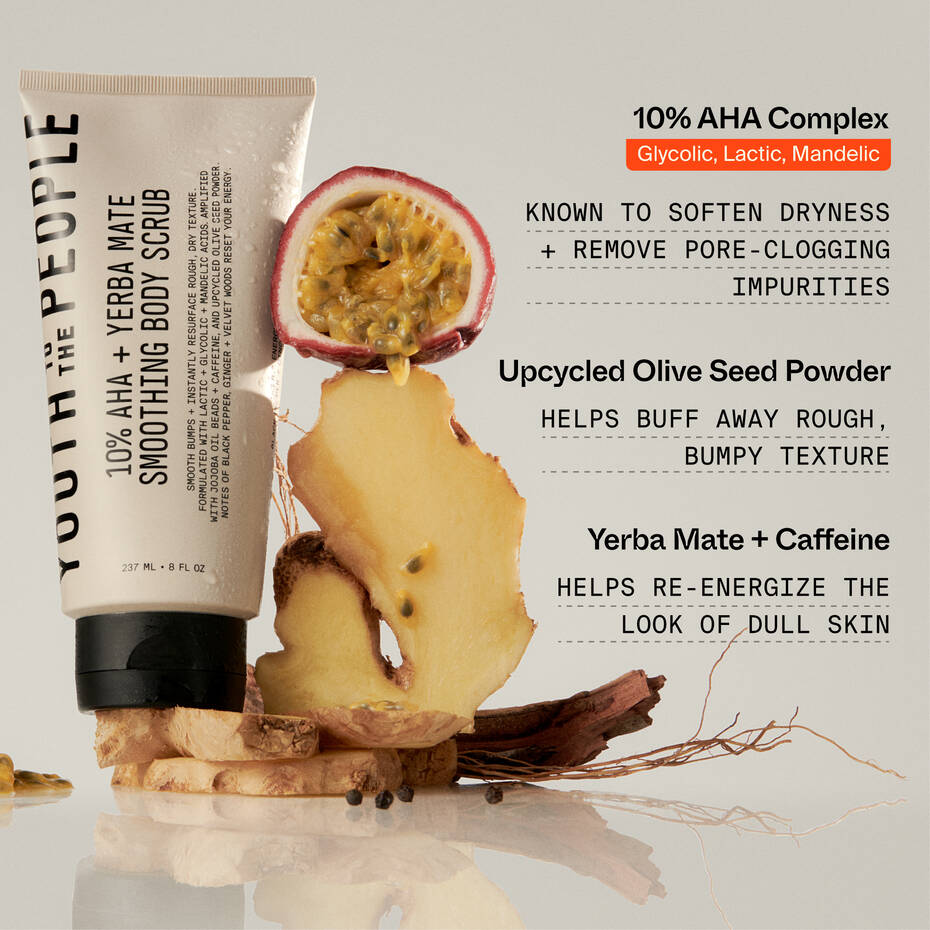 Skincare product tube labeled "Youth To The People 10% AHA + Yerba Mate Smoothing Energy Body Scrub" surrounded by fruit slices, including passionfruit and pear, with text detailing the product benefits like AHAs and caffeine.