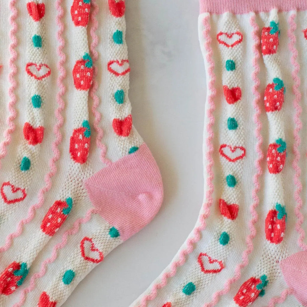 A pair of socks with a strawberry and heart pattern on a white background.