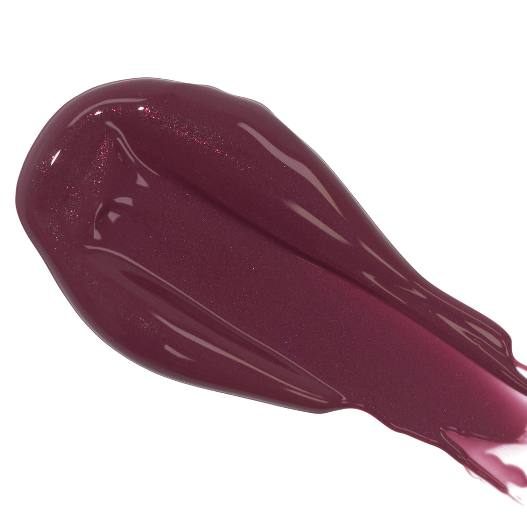 A close-up image of a smear of Fitglow Beauty Lip Color Serum with organic pomegranate on a white background.