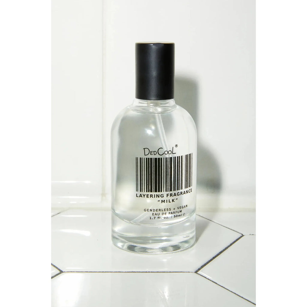 A bottle of dedcool layering fragrance on a tiled surface.