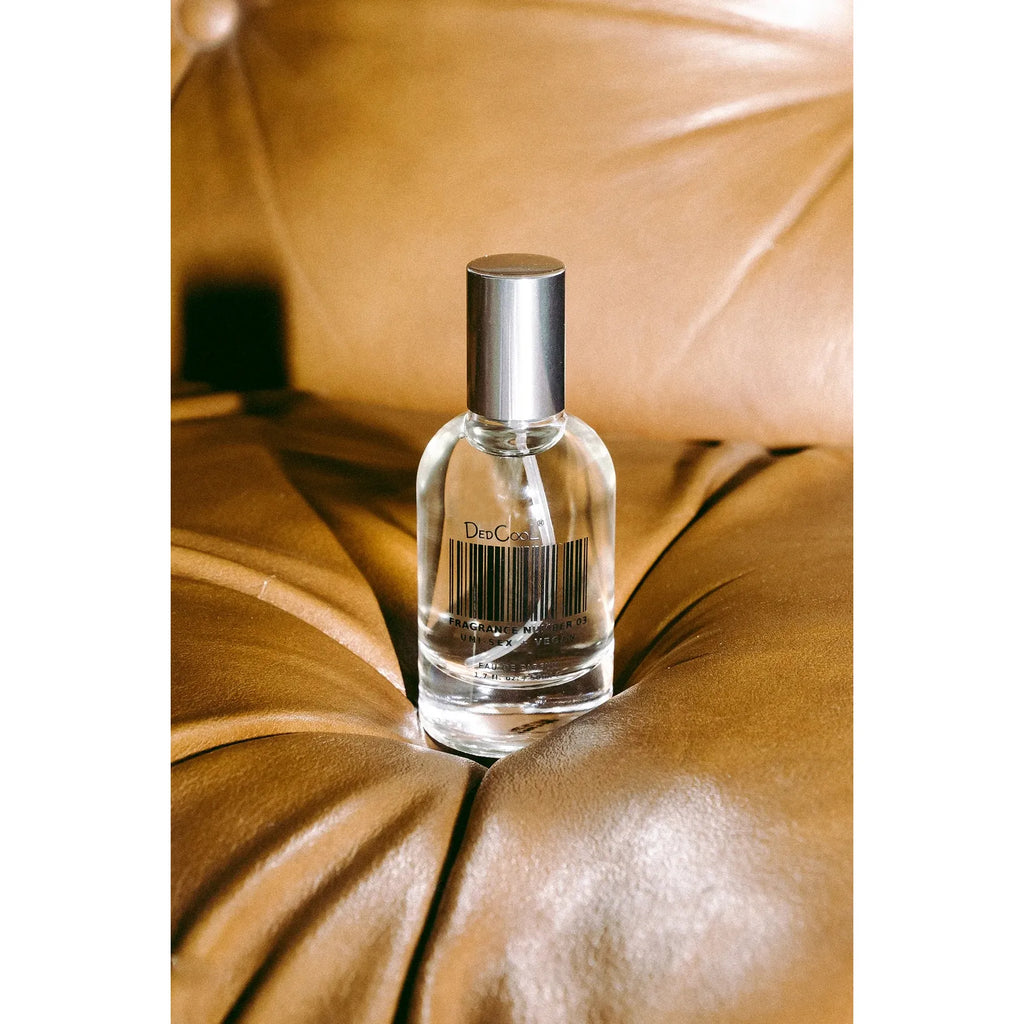 A bottle of perfume on a brown leather surface.