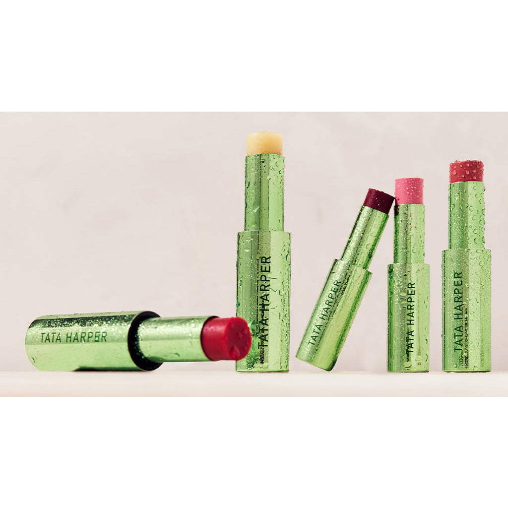 Five tubes of tata harper lip treatment in various shades on a light background.