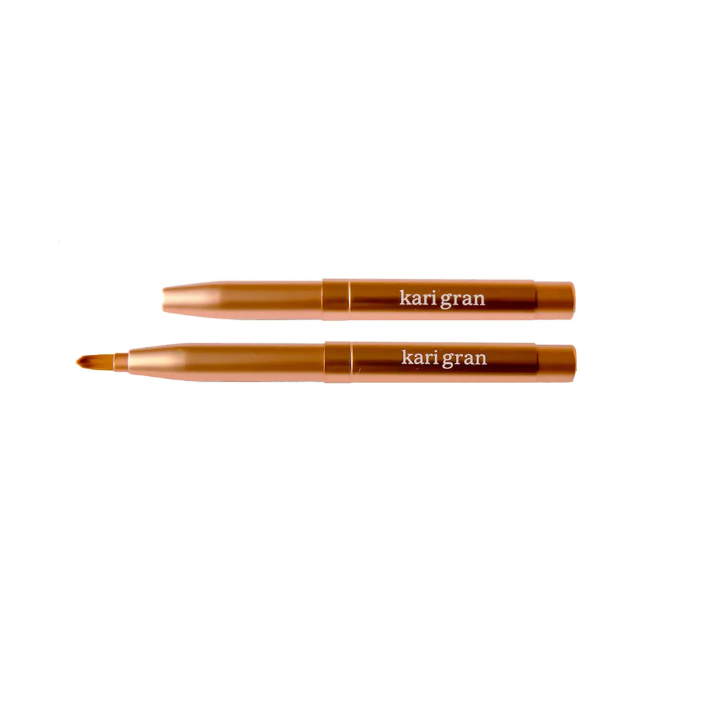 Two closed kari gran branded cosmetic pens positioned parallel to each other on a white background.