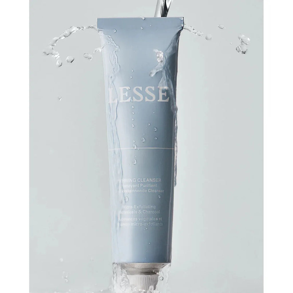 Tube of lesse refining cleanser with water splashing around it.