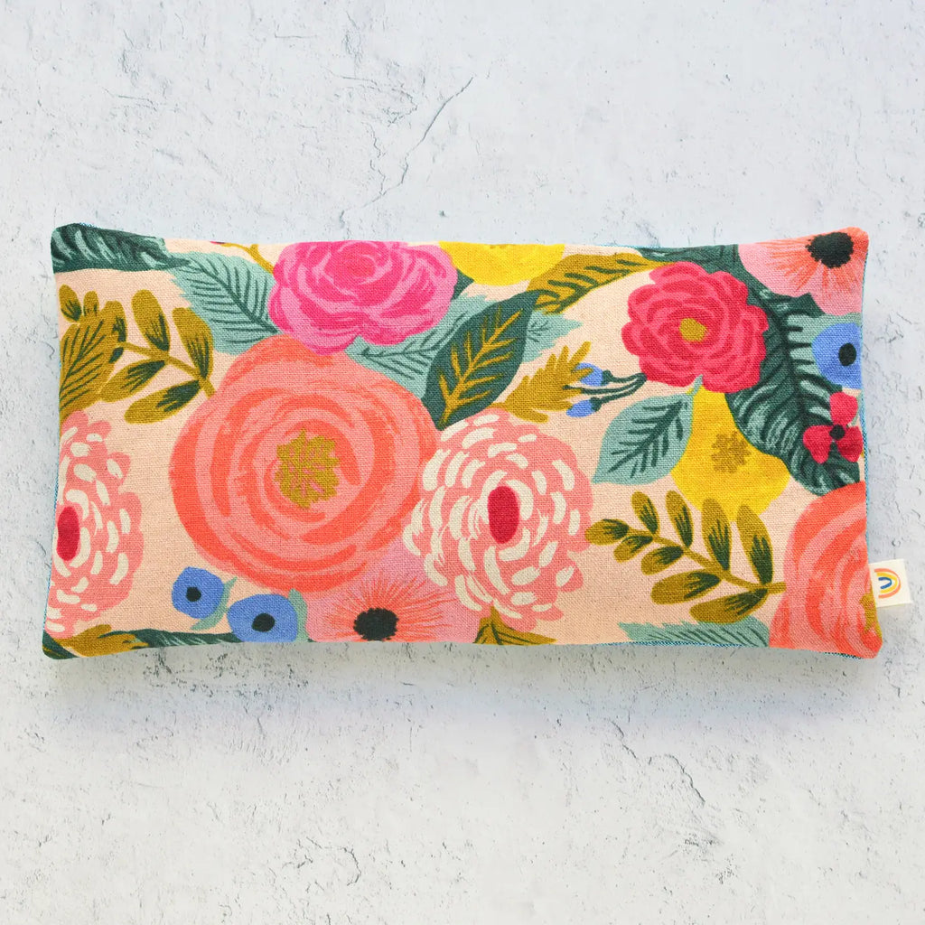 Floral patterned rectangular cushion on a textured surface.
