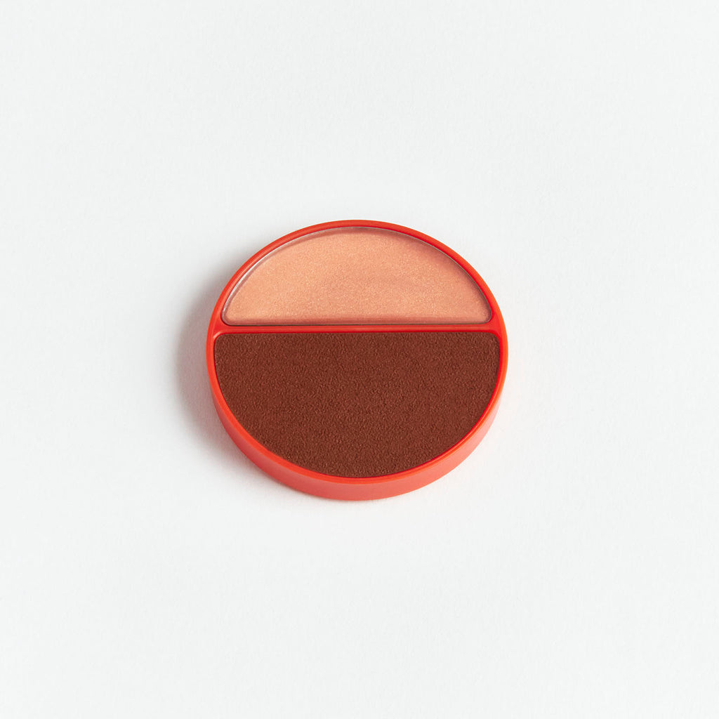 Two-toned circular cosmetic blush palette on a white background.