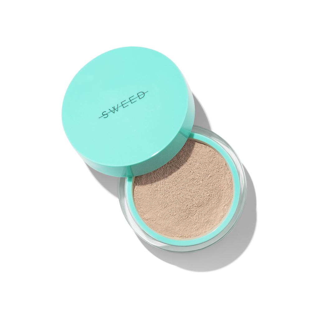 Compact cushion foundation with logo on lid, isolated on a white background.