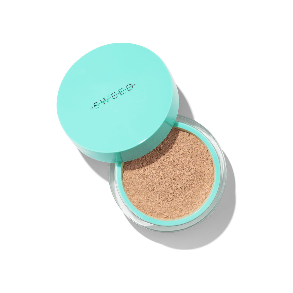 Compact powder makeup with a puff in an open turquoise case.