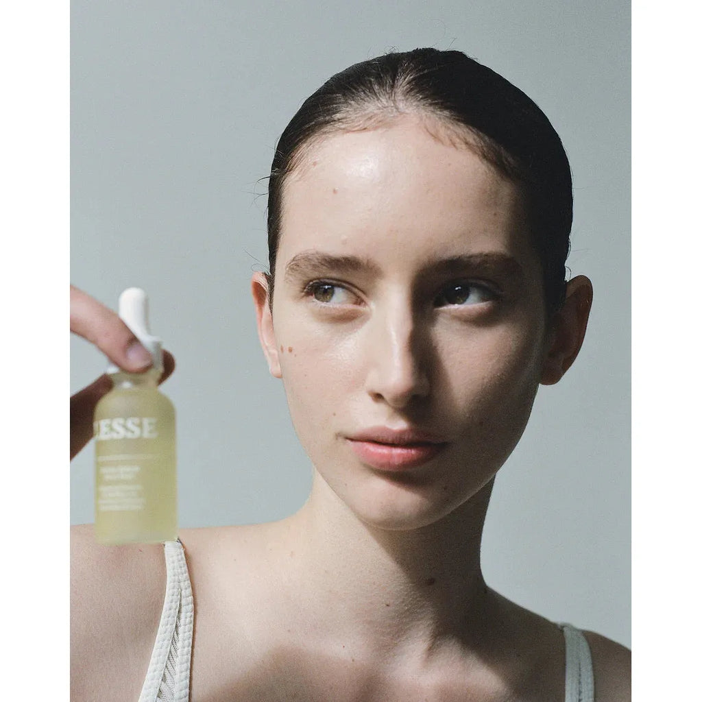 Woman holding a skincare product bottle.