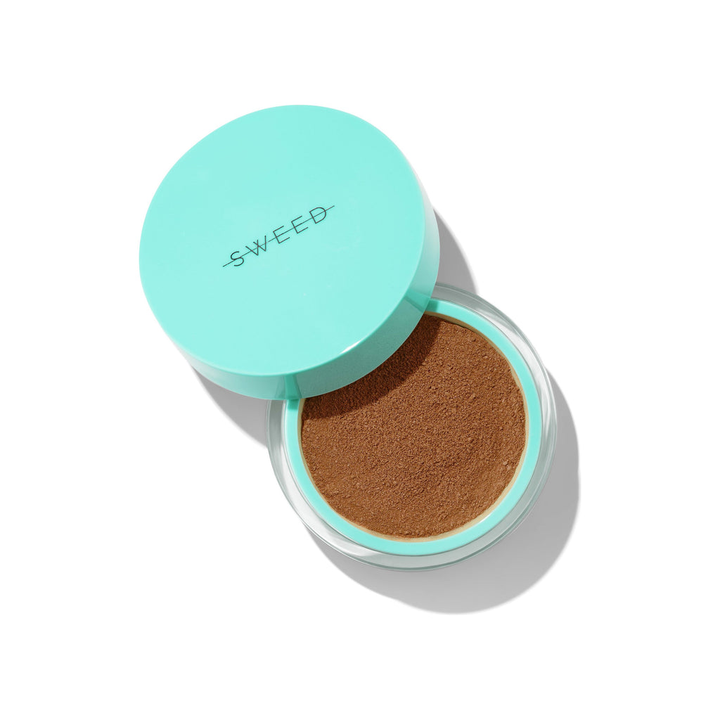 Cushion foundation compact with a teal lid, partially open to reveal the sponge applicator.