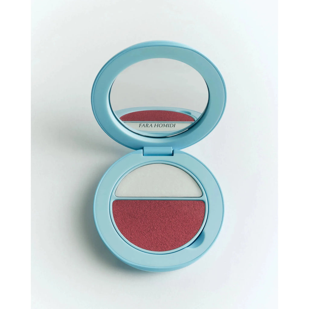 A compact makeup palette with mirror, featuring two shades: a shimmering white and a matte red.