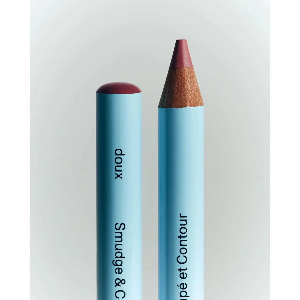 Two cosmetics pencils, one capped and one uncapped, against a neutral background.