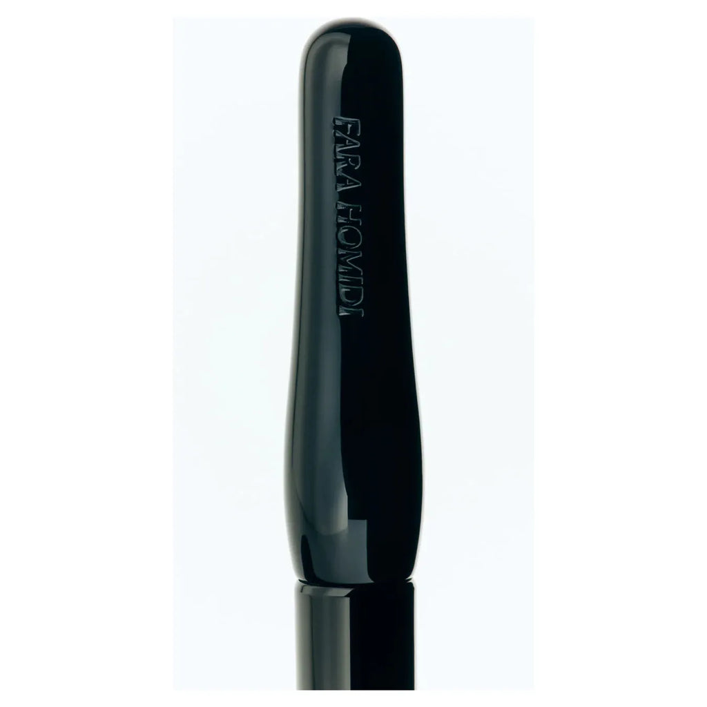 Black mascara wand with "farah homidi" text on the handle against a white background.