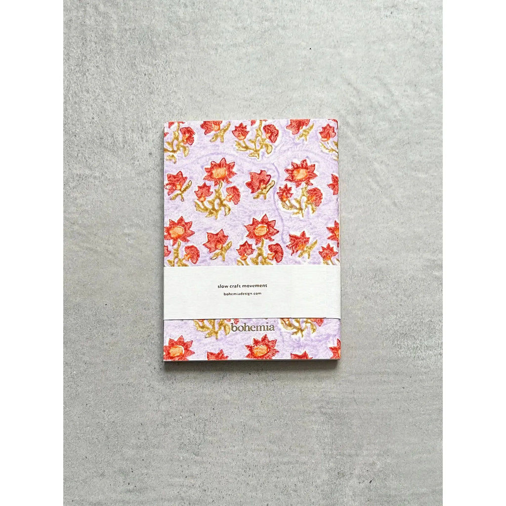 A floral patterned notebook with "slow call movement" and "bohemia" text on a grey background.