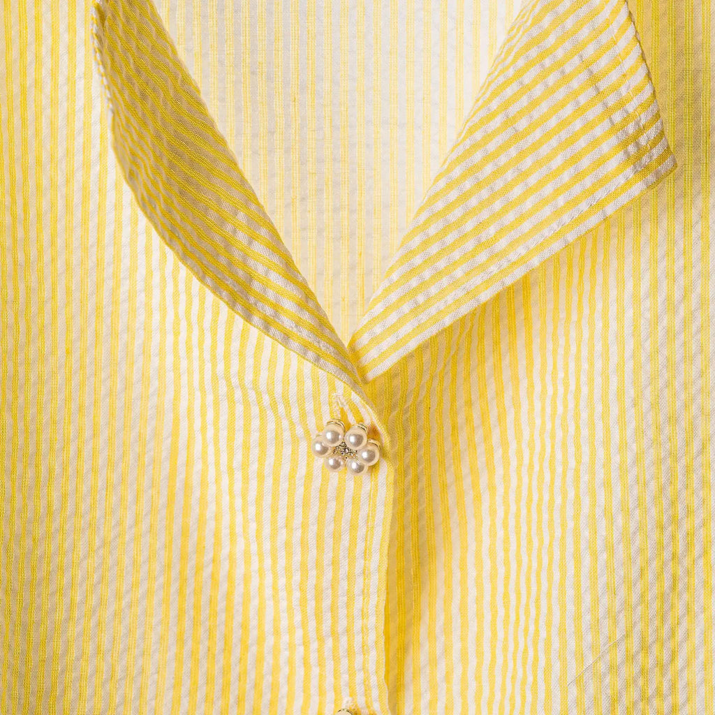 Close-up of a Lemon striped cotton seersucker shirt with a pearl button at the collar.