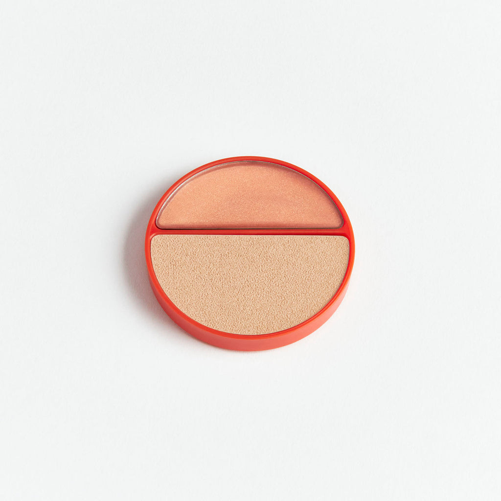 A compact with two shades of face powder against a white background.