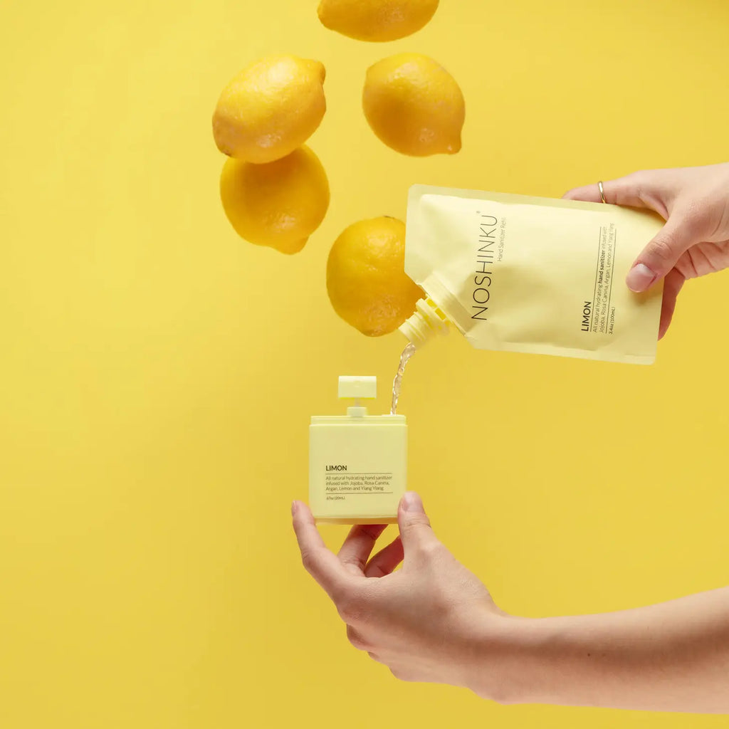 A person pours a liquid from a lemon-themed pouch into a matching container against a yellow background with lemons falling.