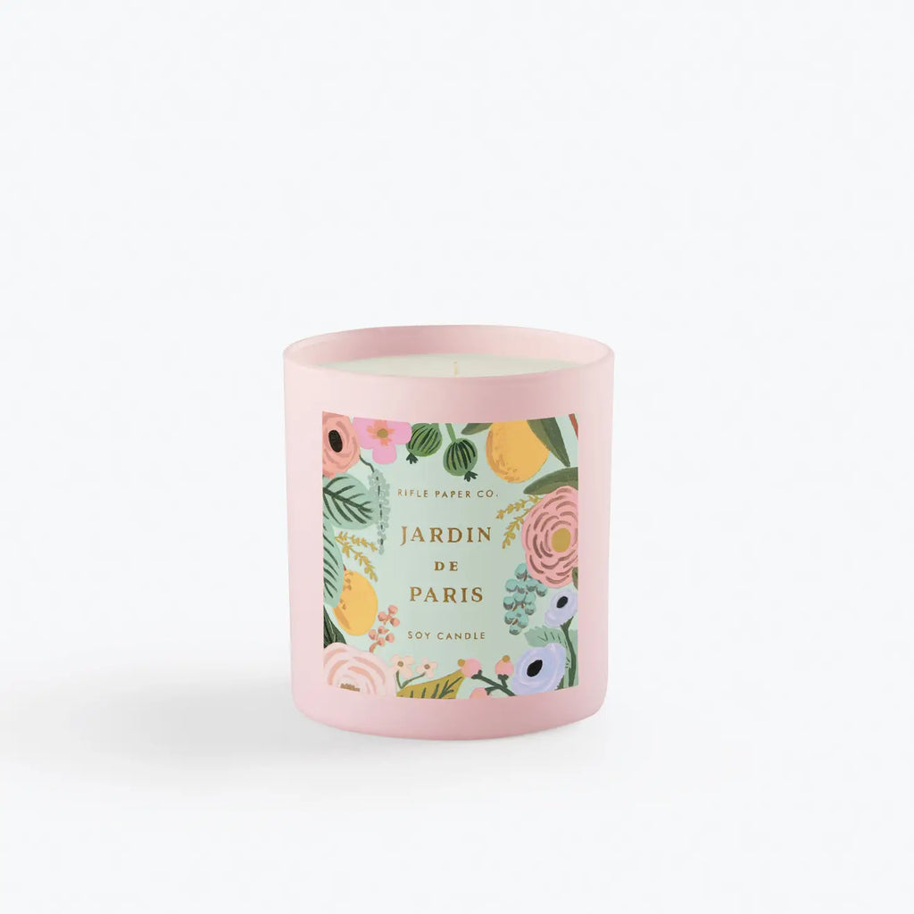 A pink soy candle with floral pattern and the words "jardin de paris" on the label, isolated on a white background.
