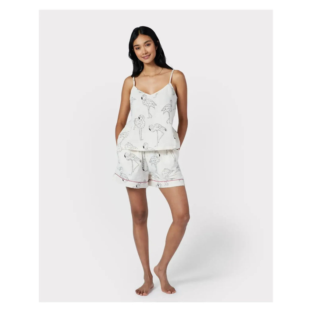 A woman wearing a Chelsea Peers Cotton Cheesecloth Flamingo Sketch Print Cami Short Pajama Set stands barefoot against a plain white background.