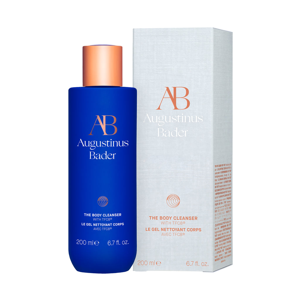 Augustinus bader body cleanser bottle next to its packaging box.