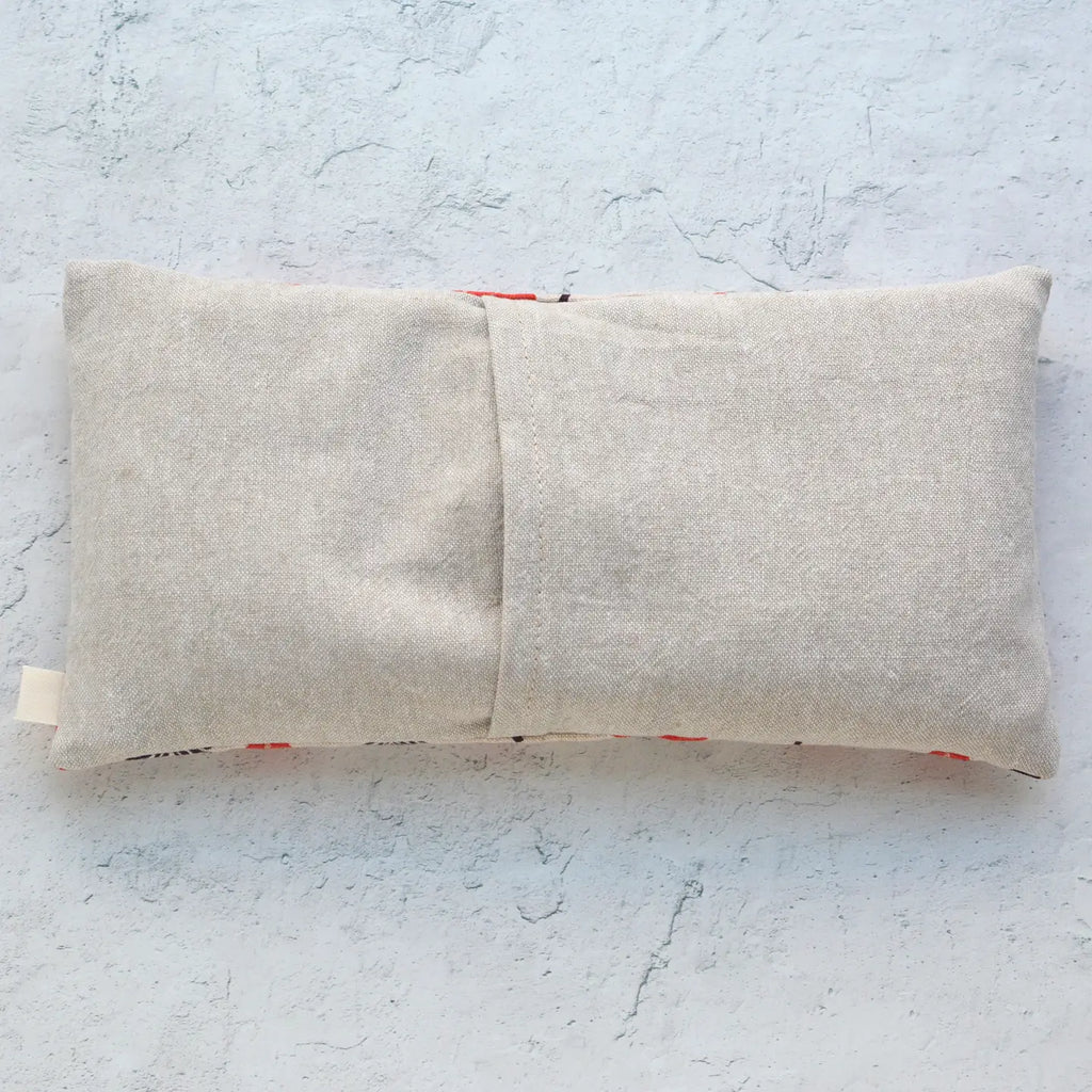 Linen pouch with a red zipper detailing on a textured surface.