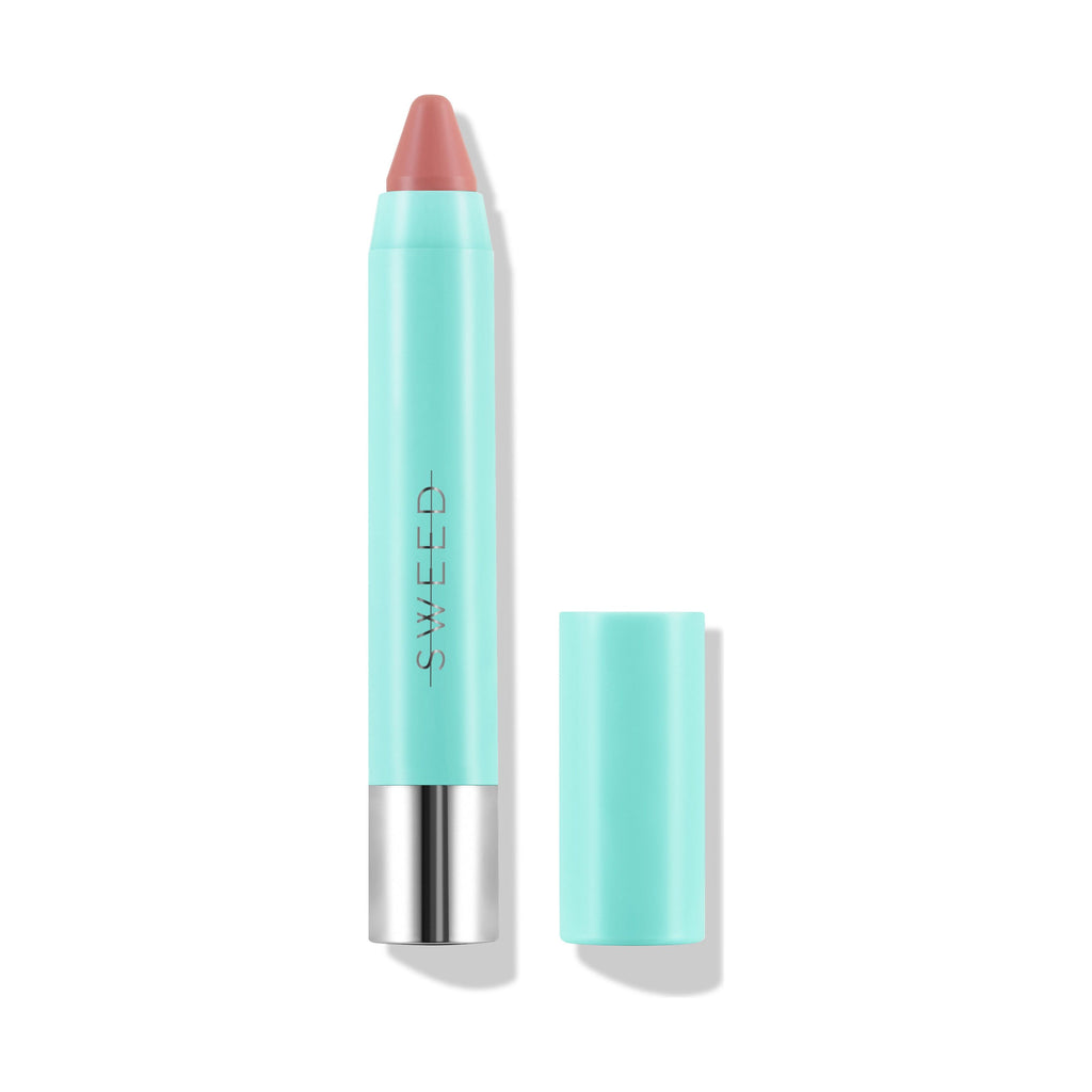A peach-colored lipstick in a turquoise tube with its cap removed next to it.