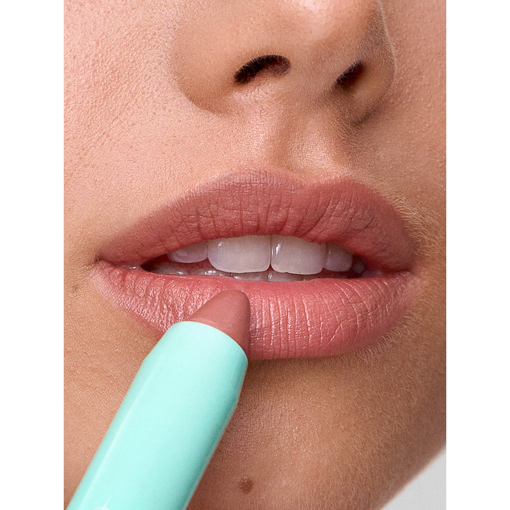 Applying lip balm to moisturized lips.
