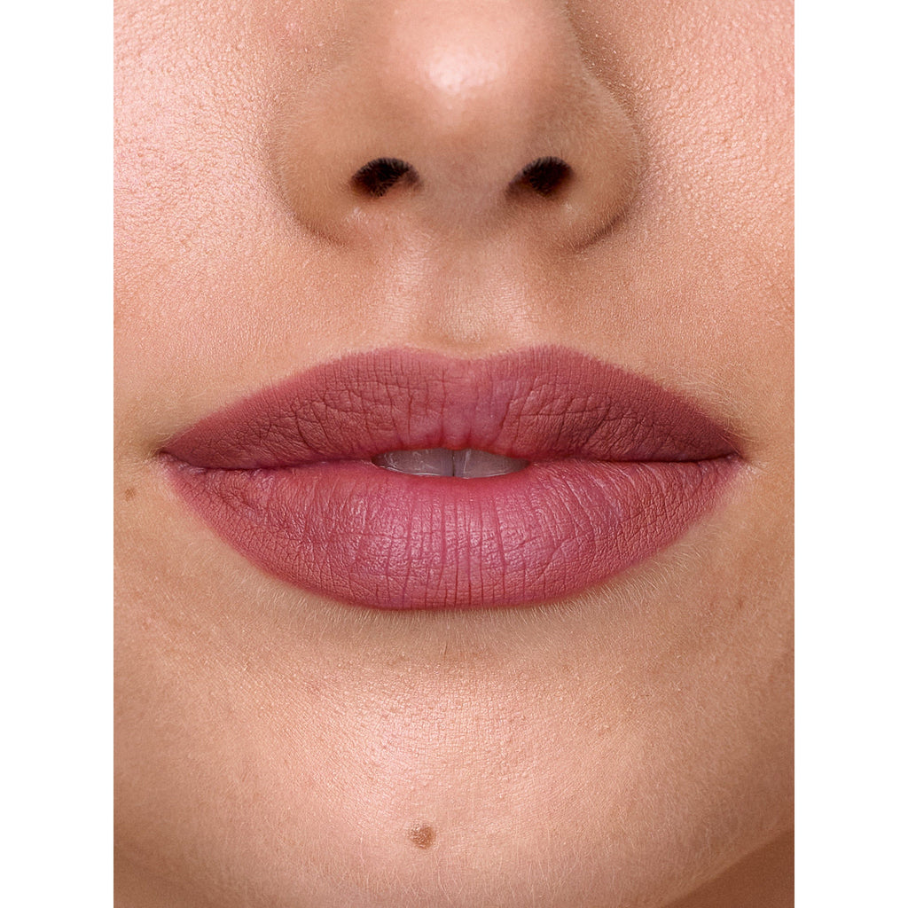 Close-up of a person's lips wearing pink lipstick.