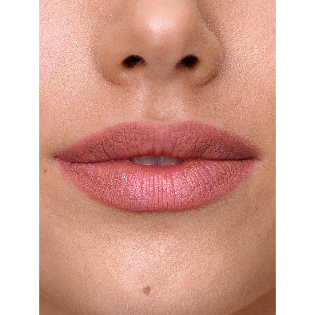 Close-up of a person's lips with pink lipstick, including the base of the nose and a small portion of the chin.
