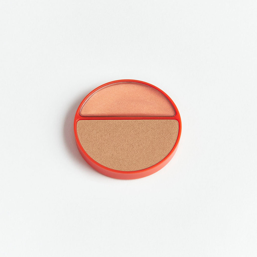 Compact powder with two shades in a round case on a white background.