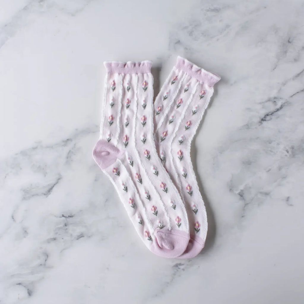A pair of pink floral knee-high socks on a marble surface.