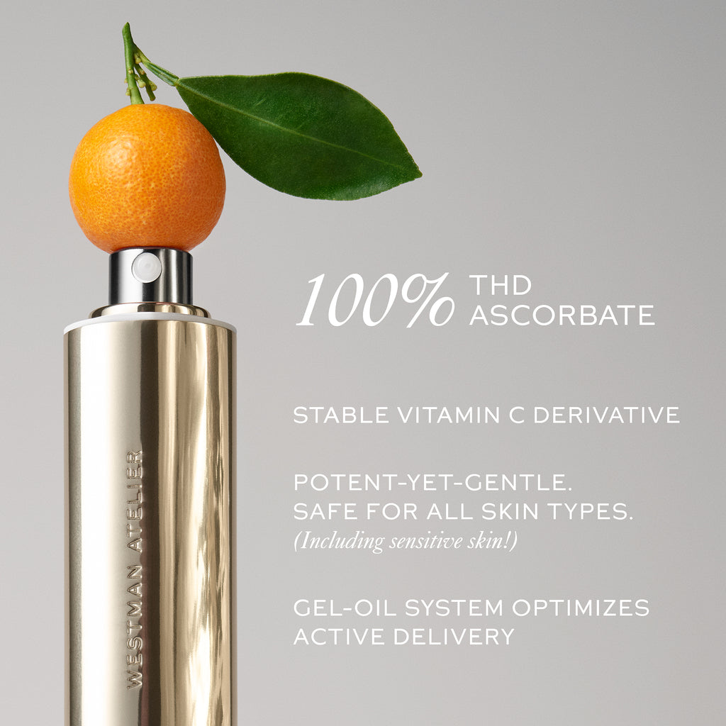 A metallic Westman Atelier Suprême C bottle with a fresh orange and leaf resting on top, against a neutral background, with text highlighting vitamin C serum benefits for hyperpigmentation.