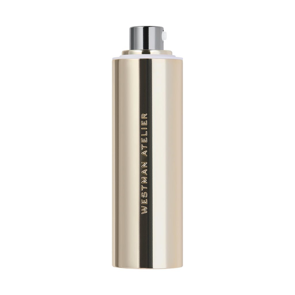 Gold and silver cylindrical bottle with a black cap labeled "Westman Atelier Suprême C serum.